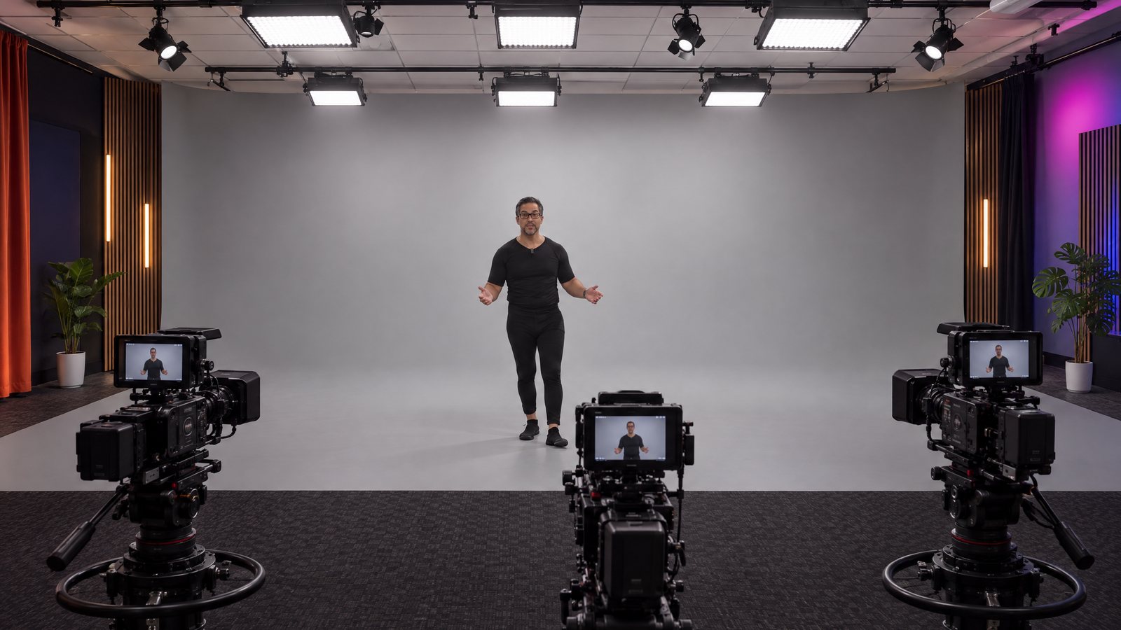 Concept of the new MWM studio: a person standing in front of a seamless grey AI Wall with a grey floor, three cameras in front of him and all the lights on the ceiling